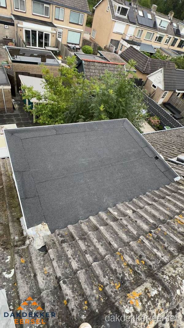Plat dak aanbouw met bitumen dakbedekking in woonwijk Eersel