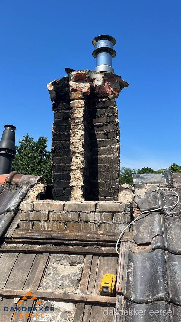 Beschadigde schoorsteen met nieuwe rookgasafvoer op oud dak in Eersel