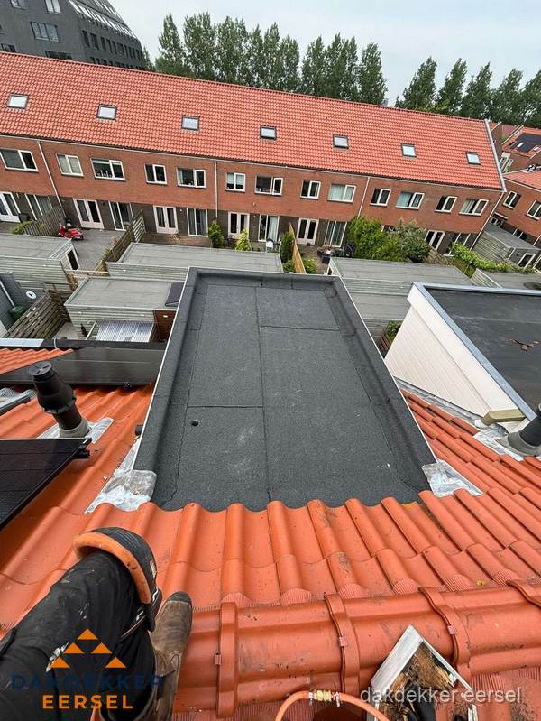 Bitumen dak reparatie op plat dak tussen dakpannen in Eersel