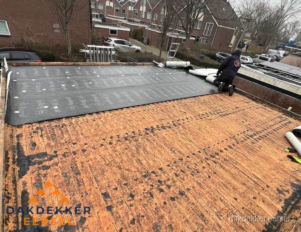 Dakdekker legt onderlaag op plat dak met houten constructie in Eersel