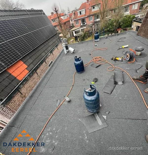 Daklekkage repareren met brandgereedschap op plat dak in Eersel