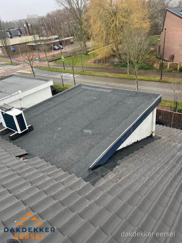 Plat dak met bitumen dakbedekking naast schuin pannendak in Eersel