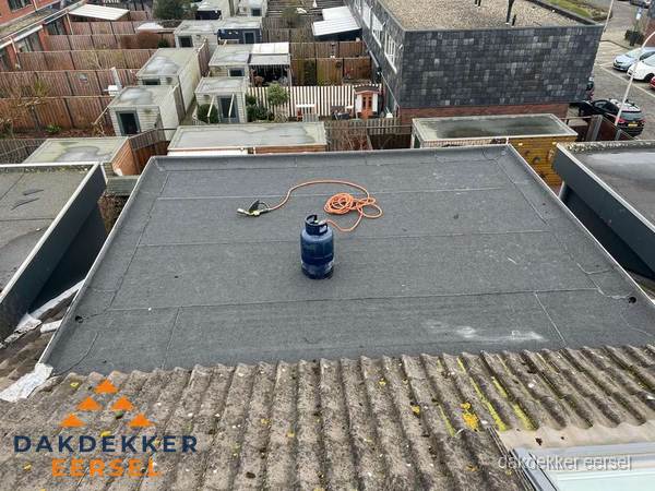 Plat dak met nieuwe bitumen dakbedekking en brandgereedschap in Eersel