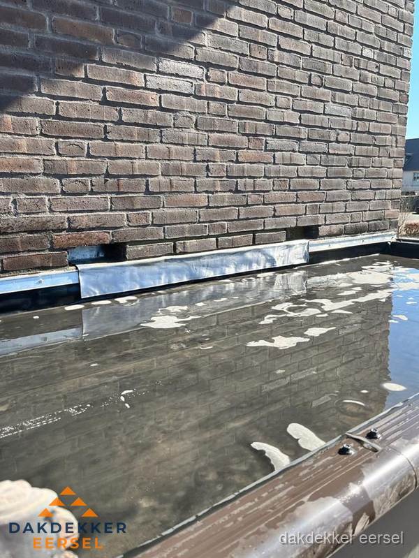 Stilstaand water op plat dak door slechte afwatering in Eersel