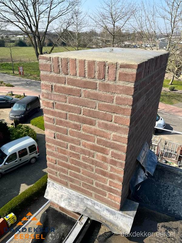Gemetselde schoorsteen met loodaansluiting op dak in Eersel