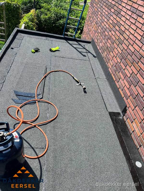 Plat dak met bitumen en brandgereedschap van dakdekkersbedrijf in Eersel